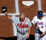 Atlanta Braves manager Bobby Cox, left, tips his cap to the crowd before receiving a bottle of wine from Tom Seaver's winery before their baseball game against the New York Mets at Citi Field in New York, Sunday, Sept. 19, 2010. Mets catcher Henry Blanco, right, presented the bottle to Cox during the pregame ceremony. (AP Photo/Kathy Willens
